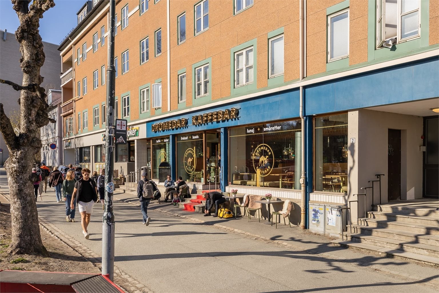 Søndagsåpen butikk og Dromedar kaffebar rett under leiligheten. Det er sykkelparkering på baksiden av bygget.