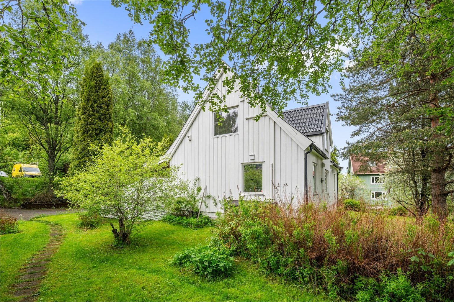 Boligens beliggenhet er skjermet, med lite innsyn og mye grønt rundt huset.