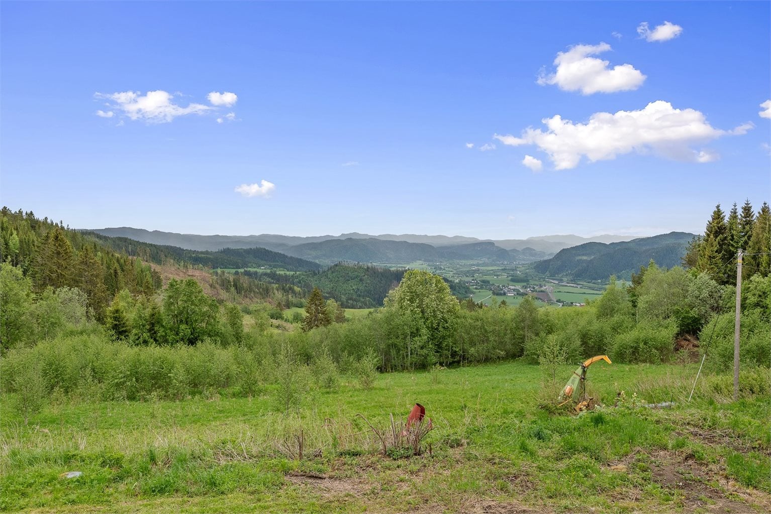 Plasseringen gir eventyrlig panoramautsikt over grønne enger, skogkledde åser og høye fjelltopper i det fjerne.