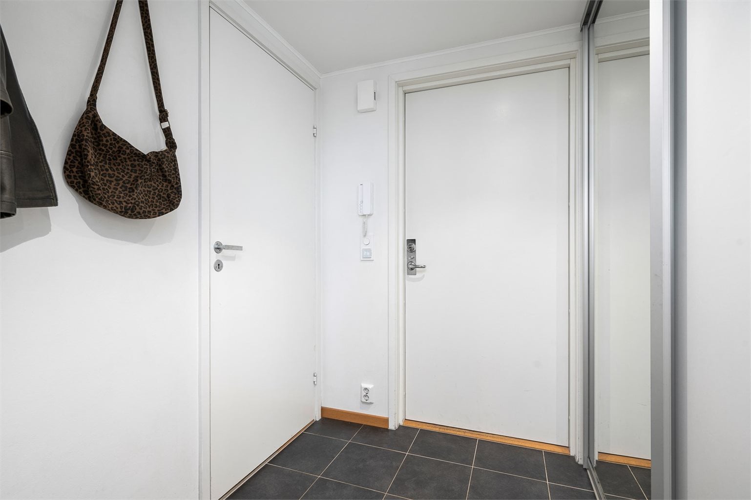 Gangen er flislagt med gulvvarme og skyvedørsgarderobe