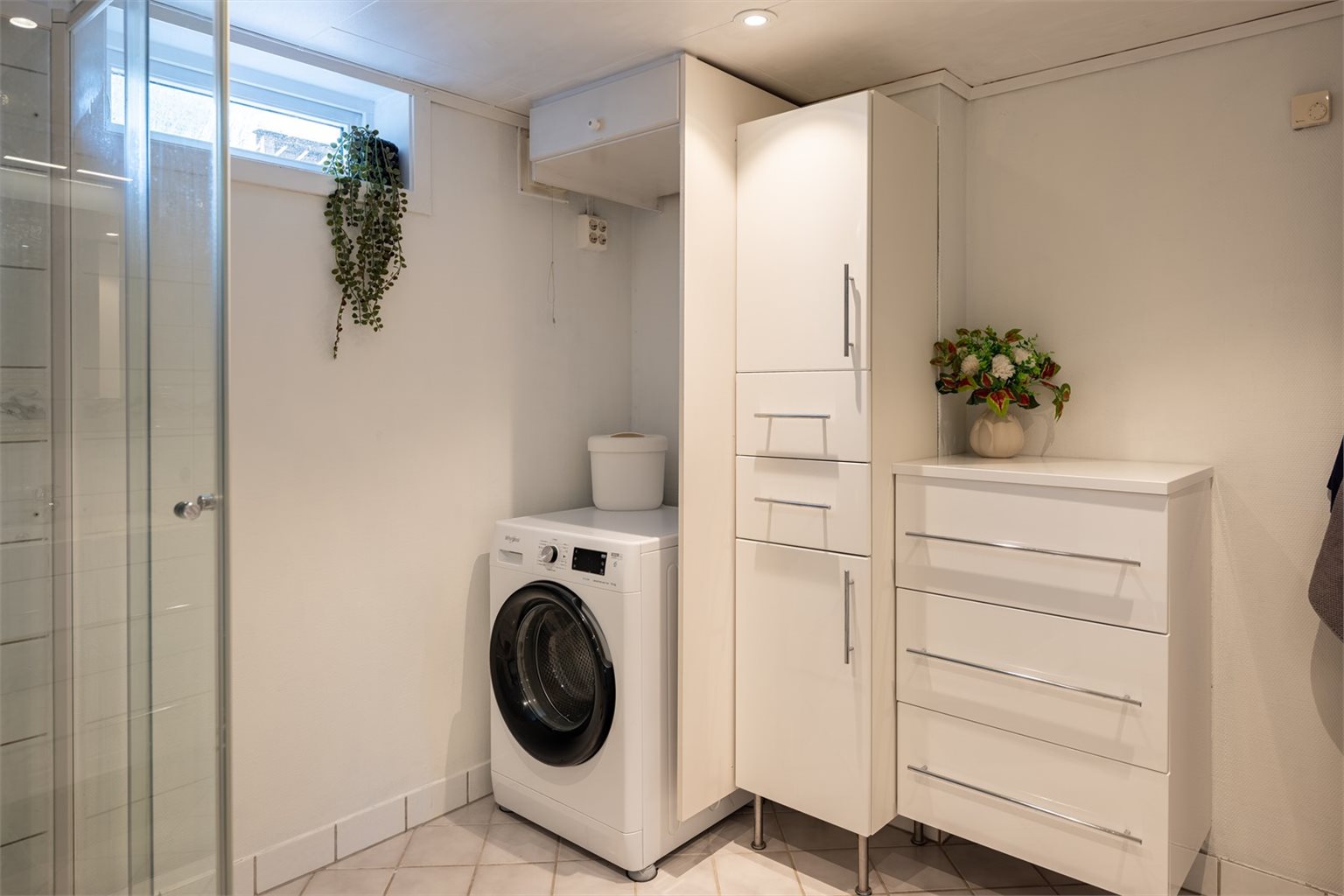 Videre byr badet på dusjkabinett, servant og opplegg for vaskemaskin.