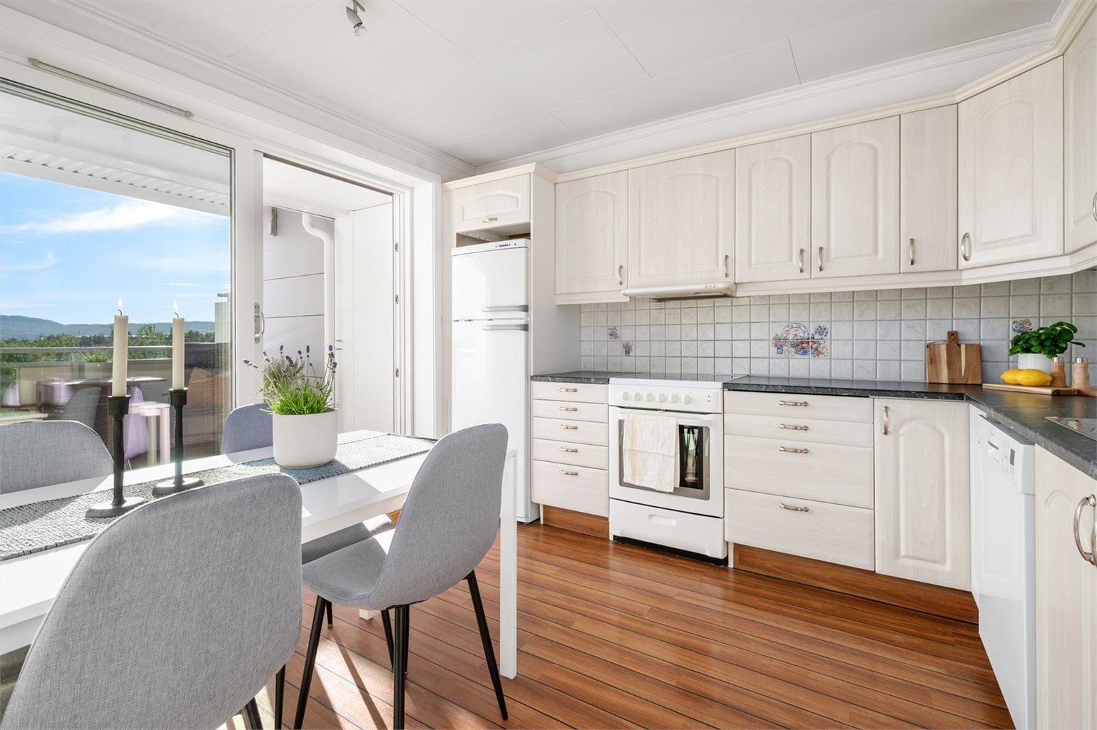 Kjøkkeninnredning med profilerte fronter og benkeplate i laminat. Kjøkkenet er oppmålt til 10 m².