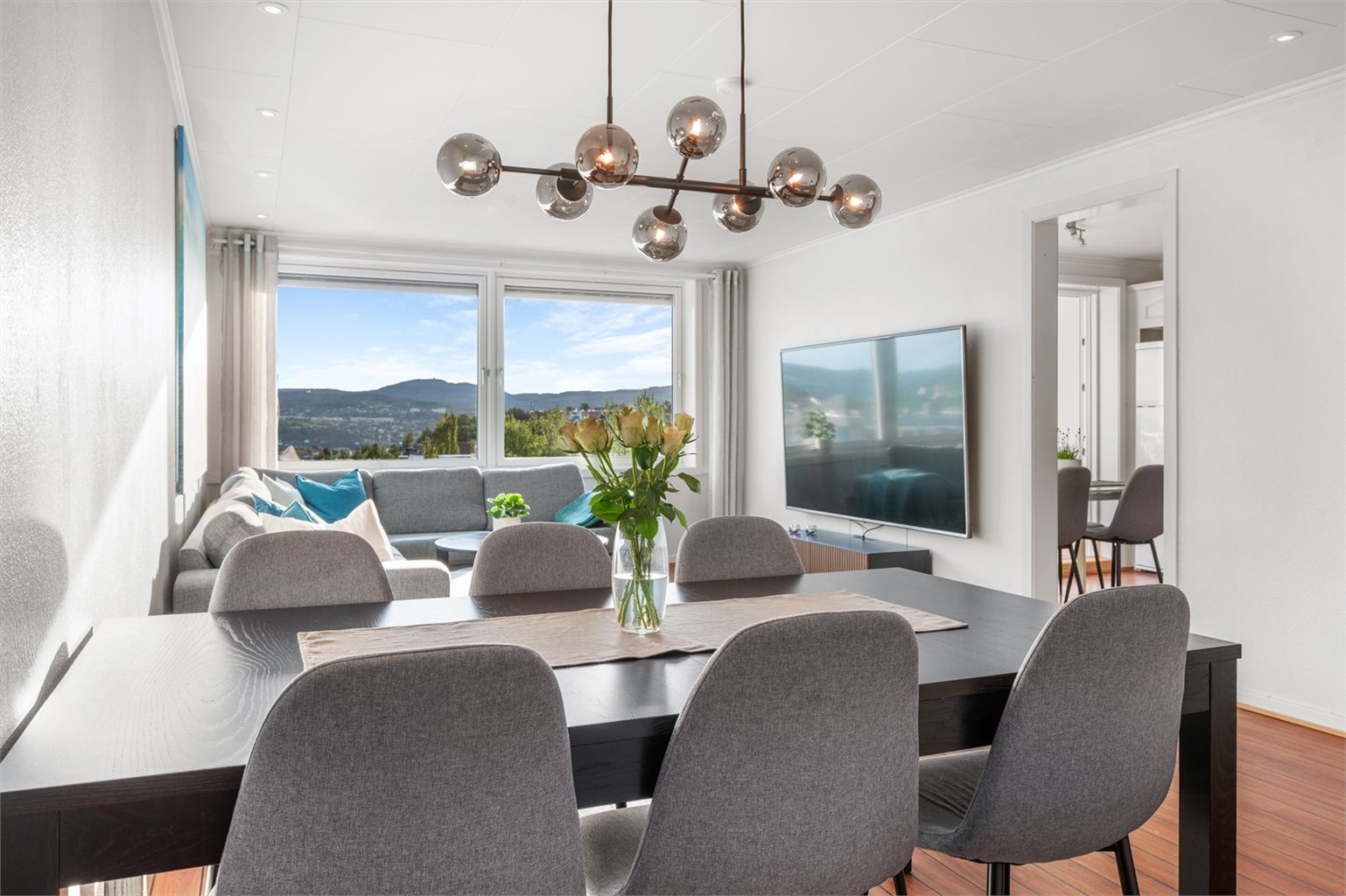 Romslig stue med plass til både sitte- og spiseavdeling. Vinduer fra 2021 med 3-lags glass slipper inn rikelig dagslys.