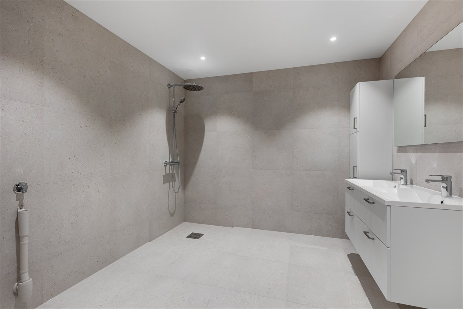 Badet er på 8,4m² og er delikat flislagt. Stort med plass til ytterligere oppbevaring