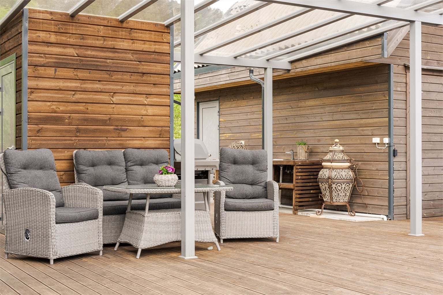 Takoverbygg på terrasse mellom hytta og utebod og naust.