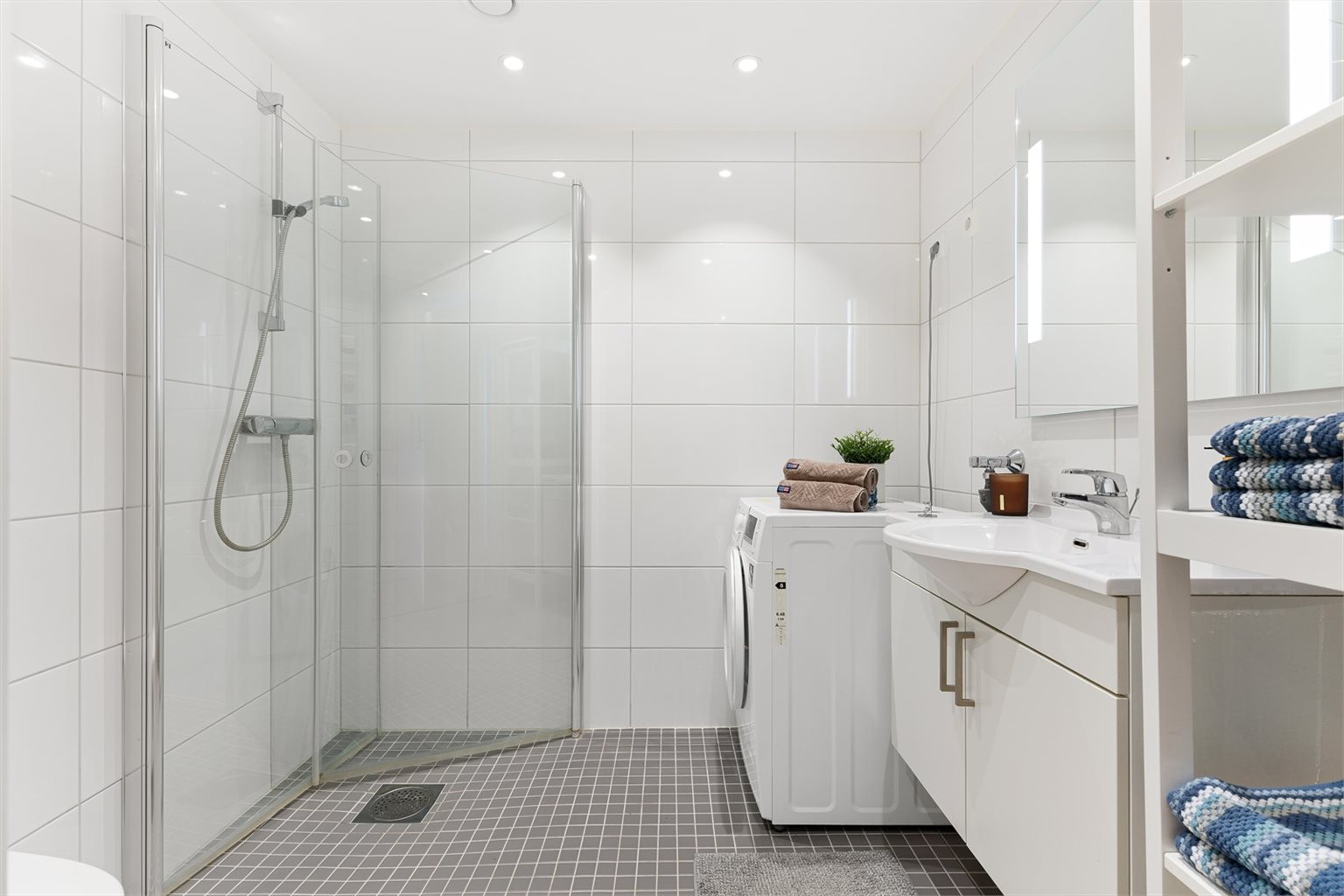 Det 4 m² store badet fremstår som innbydende med helflisede overflater, behagelig gulvvarme og downlights i tak.